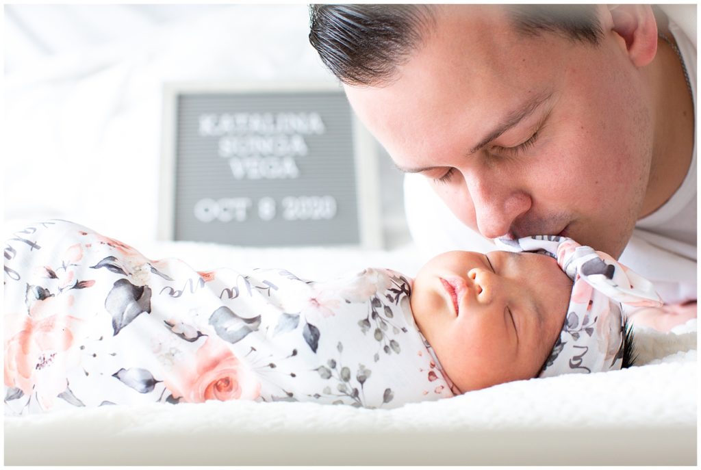 dad kissing sleepy newborn